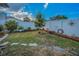 Landscaped backyard featuring a lush lawn, stepping stones, decorative fence, and a variety of plants and shrubs at 3111 Teal Ter, Safety Harbor, FL 34695