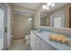 Clean bathroom with blue countertop sink, white cabinets and tiled walk-in shower with glass door at 3111 Teal Ter, Safety Harbor, FL 34695