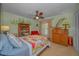 Bedroom with a ceiling fan, colorful bedding, a bookcase, and classic wood furniture at 3111 Teal Ter, Safety Harbor, FL 34695