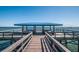 Blue roofed fishing pier featuring a wooden walkway leading out to the ocean under a clear blue sky at 3111 Teal Ter, Safety Harbor, FL 34695