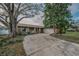 Charming single-story home featuring a brick facade and a long driveway framed by mature trees and lush landscaping at 3111 Teal Ter, Safety Harbor, FL 34695