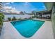 Sparkling pool with a patio and an enclosed porch surrounded by a white fence at 3111 Teal Ter, Safety Harbor, FL 34695
