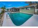 Inviting pool and backyard featuring a screened patio and manicured lawn at 3111 Teal Ter, Safety Harbor, FL 34695