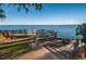 Scenic water view with a fence, bench and stone steps, highlighting the tranquil waterfront at 3111 Teal Ter, Safety Harbor, FL 34695
