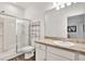 Bright bathroom features a glass shower door, modern vanity, and neutral-toned countertop at 35530 Shade Fern Ln, Zephyrhills, FL 33541
