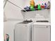 Clean laundry room with modern washer and dryer, and storage shelf at 35530 Shade Fern Ln, Zephyrhills, FL 33541