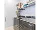 Modern laundry room featuring sleek appliances and overhead storage shelves for organization at 38189 Countryside Pl, Dade City, FL 33525