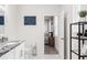 Well-lit bathroom with a granite vanity, toilet, and shelving unit at 4104 E Comanche Ave, Tampa, FL 33610