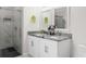 Stylish bathroom with a double vanity, granite countertop, and glass-enclosed shower at 4104 E Comanche Ave, Tampa, FL 33610