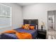 Cozy bedroom featuring a bed with an orange blanket and a window providing natural light at 4104 E Comanche Ave, Tampa, FL 33610
