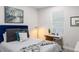 Comfortable bedroom featuring a modern desk and chair, bright lighting, and neutral decor at 4104 E Comanche Ave, Tampa, FL 33610