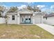 Charming single-Gathering home with a well-manicured lawn and inviting front porch featuring colorful chairs at 4104 E Comanche Ave, Tampa, FL 33610