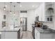 Modern kitchen with white cabinetry, stainless steel appliances, and a spacious island with seating at 4104 E Comanche Ave, Tampa, FL 33610
