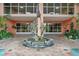 Elegant building entrance featuring a dolphin fountain and well-maintained landscaping at 4516 Seagull Dr # 614, New Port Richey, FL 34652