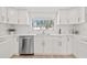 Well-lit kitchen with white cabinets, stainless steel dishwasher, marble backsplash, and a bright window at 4625 W Bay Villa Ave, Tampa, FL 33611