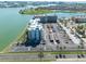 Aerial view showcasing condominium building with parking and waterfront features at 500 Treasure Island Cswy # 402, Treasure Island, FL 33706