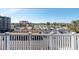 Sunny balcony view overlooking parking lot, buildings, and palm trees in the distance at 500 Treasure Island Cswy # 402, Treasure Island, FL 33706