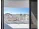 Balcony view with white railings overlooking a parking lot and distant buildings and palm trees at 500 Treasure Island Cswy # 402, Treasure Island, FL 33706