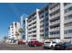 Low-angle view of a condominium building showing balconies and parking area at 500 Treasure Island Cswy # 402, Treasure Island, FL 33706
