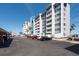 Condominium building featuring multiple stories with balconies and ample parking spaces at 500 Treasure Island Cswy # 402, Treasure Island, FL 33706