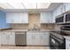 Well-lit kitchen featuring stainless steel appliances, white cabinetry, and neutral countertops at 500 Treasure Island Cswy # 402, Treasure Island, FL 33706