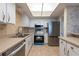 Kitchen featuring tiled backsplash, stainless steel appliances, and white cabinetry at 500 Treasure Island Cswy # 402, Treasure Island, FL 33706