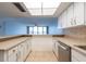 Bright kitchen with tiled flooring, white cabinets, and a breakfast bar overlooking living area at 500 Treasure Island Cswy # 402, Treasure Island, FL 33706