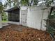 Exterior view of a shed and screened patio in a backyard with leaves covering the ground at 5439 County Road 579, Seffner, FL 33584