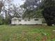 Quaint single-story home featuring a classic design, complemented by a lush front yard and mature trees at 5439 County Road 579, Seffner, FL 33584