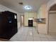Kitchen featuring white tile flooring, black appliances, and wood trim at 5439 County Road 579, Seffner, FL 33584