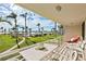 Relaxing balcony view overlooking lush green lawn, tall palm trees, and waterfront at 6021 Bahia Del Mar Cir # 234, St Petersburg, FL 33715