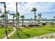 Expansive green lawn with mature palm trees, and a waterfront pool and lounge area at 6021 Bahia Del Mar Cir # 234, St Petersburg, FL 33715