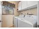 Well-lit laundry room with washer, dryer, storage cabinets, and a window for natural light at 6021 Bahia Del Mar Cir # 234, St Petersburg, FL 33715