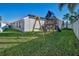 Large backyard with a swing set, slide, and plenty of green space, offering a fun and safe play area for children at 632 Addison Ne Dr, St Petersburg, FL 33716