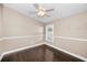 Bedroom with a ceiling fan, dark wood floors, and a bright window overlooking the yard at 632 Addison Ne Dr, St Petersburg, FL 33716
