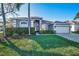 Charming home with a well-manicured lawn, lush landscaping, and an attached two-car garage at 632 Addison Ne Dr, St Petersburg, FL 33716
