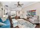 Spacious living room with hardwood floors, a ceiling fan, an elegant rug, and sliding glass doors leading to the screened pool at 632 Addison Ne Dr, St Petersburg, FL 33716