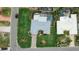Aerial view of a well-maintained home featuring a pool, lush landscaping, and a driveway at 8000 13Th S Ave, St Petersburg, FL 33707