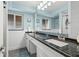 Updated bathroom featuring a dark granite vanity countertop, white cabinetry, and a large vanity mirror at 8000 13Th S Ave, St Petersburg, FL 33707