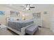 Bedroom features a king size bed, a ceiling fan, wood floors, and a bench at the foot of the bed at 8000 13Th S Ave, St Petersburg, FL 33707