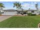Inviting single-story home featuring well-maintained landscaping, a brick paver driveway, and mature palms at 8000 13Th S Ave, St Petersburg, FL 33707