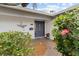Inviting front entrance with a blue door, heron artwork, and lush landscaping with blooming hibiscus at 8000 13Th S Ave, St Petersburg, FL 33707