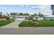 Charming home with a lush lawn, mature palm trees, and a well-maintained circular garden bed at 8000 13Th S Ave, St Petersburg, FL 33707