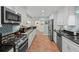 Stylish kitchen with granite counters, stainless steel appliances, white cabinets, and updated backsplash at 8000 13Th S Ave, St Petersburg, FL 33707