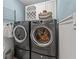 Laundry room with new gray washer and dryer and cabinets for storage at 8000 13Th S Ave, St Petersburg, FL 33707