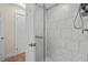 Bathroom featuring glass enclosed shower with white marbled tile, handheld fixture, and tiled floor at 8000 13Th S Ave, St Petersburg, FL 33707