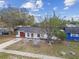 Aerial view of white home with red garage door, bench, mature trees and new roof at 8930 94Th Ave, Seminole, FL 33777