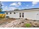 A white home exterior features double doors opening to a brick paver patio in the backyard at 8930 94Th Ave, Seminole, FL 33777