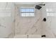 Bathroom shower and tub with white marble tile and black shower fixtures at 8930 94Th Ave, Seminole, FL 33777