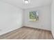 Sunlit bedroom with wood-look floors and a large window at 8930 94Th Ave, Seminole, FL 33777